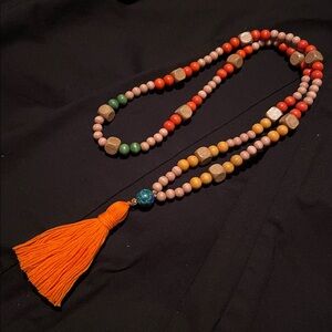 Hand assembled beaded necklace orange tassel